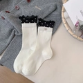 Cream crew socks with black ruffled cuffs and heart print featuring a silver charm detail - White