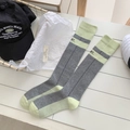 Calze sportive grigie e verde neon con scritta RT in un flat lay dallo stile minimal - Grigio
