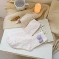 Creamy white plush coral fleece socks with purple bow detail for winter warmth - White