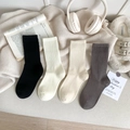 Women's rib-knit crew socks in black, white, and grey shown in a cozy home setting - One Size / Mixed Colors