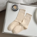 Beigefarbene Crew-Socken mit elastischem Rippbündchen in minimalistischem Ambiente - Einheitsgröße / Haferflocken
