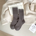Coffee brown ribbed crew socks made of combed cotton displayed on a cozy blanket - One Size / Dark Gray
