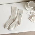 Off-white cotton crew socks with blue smiling face embroidery and ribbed knit texture - Grayish White