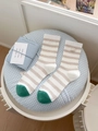 Striped cotton crew socks in beige and green with serendipity label on plaid background - One Size / Milk Tea