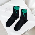 Chaussettes en coton peigné noir avec motif trèfle à quatre feuilles vert en vue 45° - Taille unique / Trèfle-Noir