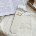 Calze in maglia a coste beige con bordo grigio esposte su uno sfondo in tessuto bianco - Taglia unica / Bianco