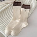 Beige gestreifte Wadenstrümpfe mit Vintage-Knopfdetail auf Strickhintergrund - Cremefarben Patchwork Knopf Stil (Weiß Knopf)
