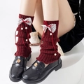 Detail of burgundy knit leg warmers with white lace bows and pom-poms on black loafers - One Size / Ribbon Bowknot