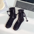 Calze termiche in pile corallo nero con fiocchi e ciondoli a cuore su tavolo bianco - Taglia unica / Nero