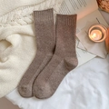 Brown ribbed wool socks in a cozy home setting with a candle and an open book - Light Coffee