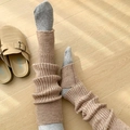 Detailed knit texture of light camel leg warmers over grey socks on wooden floor - One Size / Brown