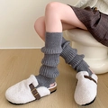 Grey knit leg warmers paired with white plush mule shoes on light wood floor - One Size / Gray