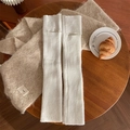 Winter-Strickset mit weißen Beinstulpen und beige Schal auf einem Holztisch - Einheitsgröße / Weiß