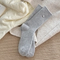 Thick grey wool knit socks with decorative silver pendant in cozy lifestyle setting - One Size / Light Gray