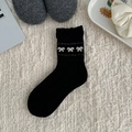 Chaussettes en laine noires style japonais avec motifs nœuds blancs et texture tricotée - Noir