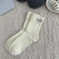 Gemütliche cremefarbene Rippstrick-Baumwollsocken mit dekorativem Webetikett auf Plüsch - Einheitsgröße / Creme