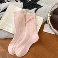 Rosafarbene Wollsocken mit Rippenmuster und Schleife auf einem Vintage-Buch serviert - Einheitsgröße / Rosa