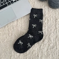 Thick grey Fair Isle wool socks with white bow pattern on cozy home background - One Size / All-over Bows