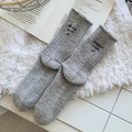 Thick grey wool socks with black letter embroidery in a cozy home setting - One Size / Light Gray