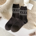 Dark brown wool socks with fair isle heart and tree patterns on a soft plush rug - One Size / Coffee