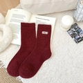 Chaussettes en laine bordeaux avec broderie Nice sur un tapis en peluche blanc - Taille unique / Bordeaux