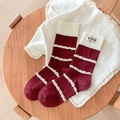 Calze a righe rosso scuro con volant e simpatica toppa a fumetto su sgabello di legno - Taglia unica / Rosso