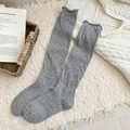 Cozy grey slouch socks with rolled edges on a warm beige rug with winter accessories - Light Gray