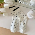 Punkte-Socken in Creme mit schwarzem Rüschenrand, Schleife und kleinem Glöckchen - Silberne Schleife