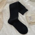 Thick black knitted calf socks for winter with warm ribbed cuffs on white fabric - One Size / Black