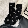 Cozy black wool blend mid-calf socks with white bow patterns and flecked dot yarn - One Size / Black