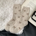 Oatmeal thick wool socks with brown bow pattern on a cozy decorative background - One Size / Beige