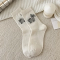 Calze di lana beige da donna con gatto e fiocco a quadretti in un ambiente accogliente - Bianco