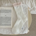 Calze bianche con bordo rosa a volant e fiore 3D in un ambiente domestico accogliente - Taglia unica / Bianco