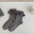 Gray ribbed knit crew socks featuring dark charcoal ruffled edges and black bow patterns - One Size / Medium Grey