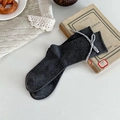 Dark gray knit mid-calf socks with vintage plaid bow tie detail on white surface - One Size / Dark Gray