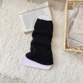 Classic black ribbed knit leg warmers for women in a cozy minimalist home setting - One Size / Black