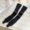 Elegant black vertical ribbed knit leg warmers with stirrup design in a flat lay view - One Size / Black