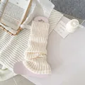 Chic cream white knitted leg warmers with vertical ribbed texture on display card - Creamy White