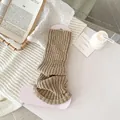 Beige ribbed knit leg warmers in a cozy home setting with a minimalist slouchy style - Khaki
