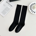 Classic black knee-high school socks featuring vertical rib knit texture for women - One Size / Black