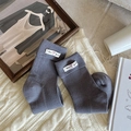 Dark grey ribbed cotton mid-calf socks with folded cuff and brand label on knit blanket - One Size / Gray