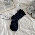 Klassische dunkelblaue Baumwollsocken mit hellblauen Streifen auf weißem Bettzeug - Schwarz