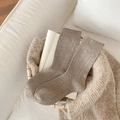 Women's dark beige mid-calf socks with vertical ribbed texture in a cozy home setting - One Size / Light Coffee