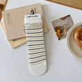 Calze di cotone beige con strisce gialle e marroni in un allestimento piatto retrò - Righe Sottili