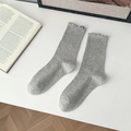 Graue Strick-Wadenstrümpfe mit bunten Sprenkeln und Rüschenbündchen auf weißem Grund - Hellgrau
