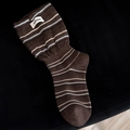 Brown striped knit socks with blue accents and brand label on a dark background - Coffee Blue Stripes