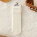 Beige knitted slouch socks with ribbed texture and slouchy cuffs in packaging - One Size / White