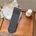 Calze grigio scuro con ricamo floreale esposte su un vassoio di legno - Taglia unica / grigio scuro