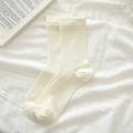 Minimalist cream white mid-calf socks in soft breathable knit on white fabric background - Creamy White