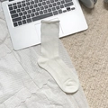 Beige Lolita lace mesh socks with vertical stripes and bow details in a cozy home setting - Rolled Edge
